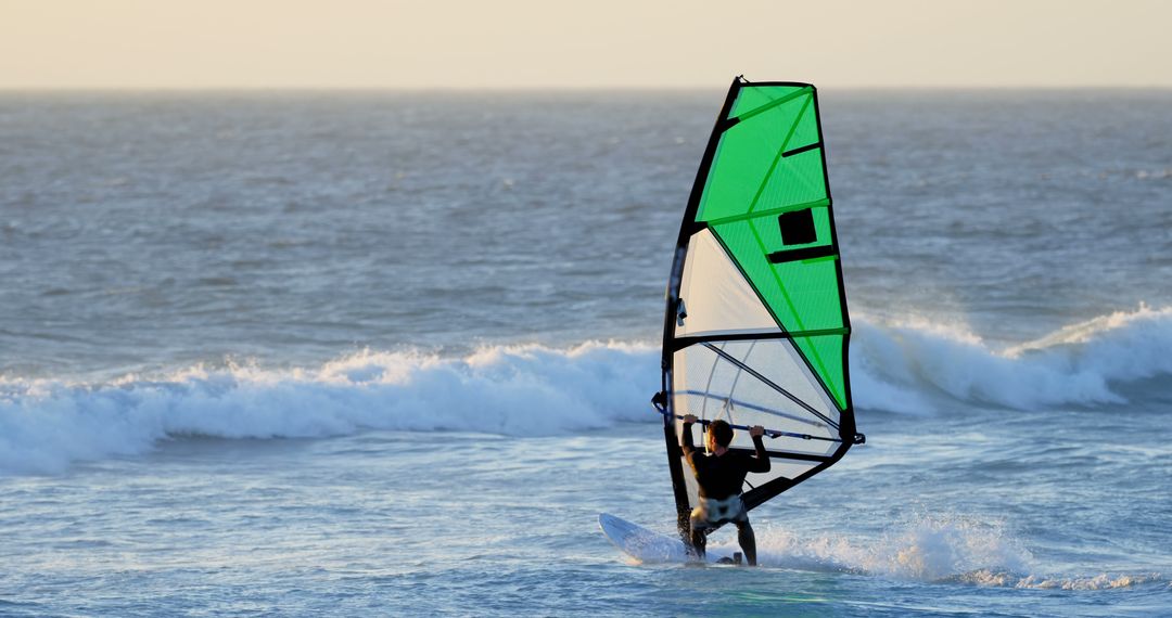 Man Wind Surfing on Ocean Waves at Sunset - Free Images, Stock Photos and Pictures on Pikwizard.com