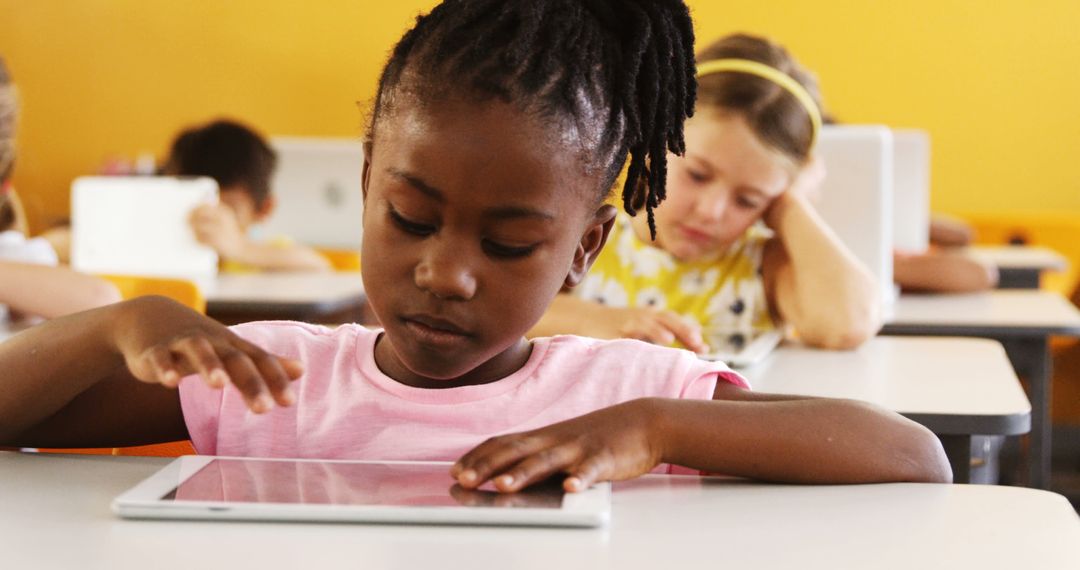 Young Girl Using Tablet in Classroom with Classmates - Free Images, Stock Photos and Pictures on Pikwizard.com