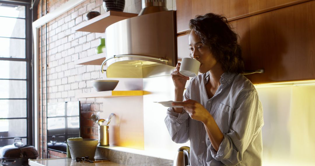 Woman Drinking Coffee in Modern Kitchen with Wooden Cabinets - Free Images, Stock Photos and Pictures on Pikwizard.com