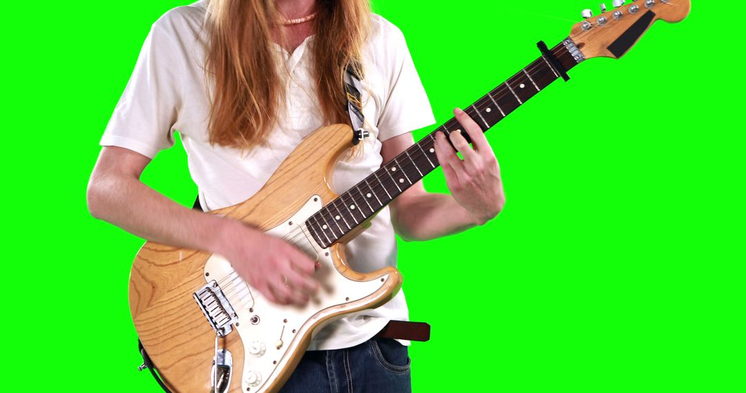A Caucasian man is playing an electric guitar against a green screen background, with copy space - Free Images, Stock Photos and Pictures on Pikwizard.com