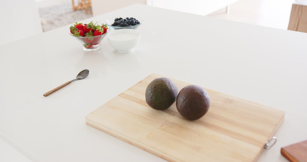 Fresh Avocados on Cutting Board with Berries and Yogurt Spread
