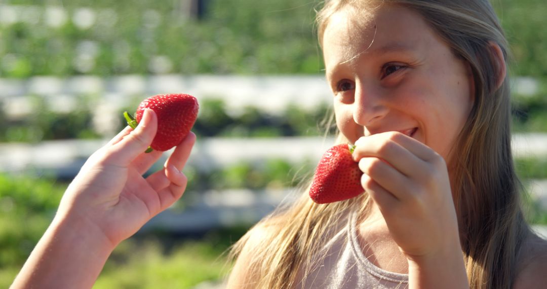 Teenage Caucasian girl enjoys fresh strawberries outdoors, with copy space - Free Images, Stock Photos and Pictures on Pikwizard.com