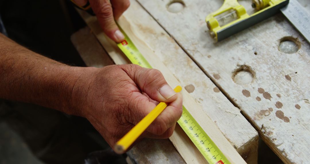 Craftsman Measuring Wood with Tape Measure and Pencil - Free Images, Stock Photos and Pictures on Pikwizard.com