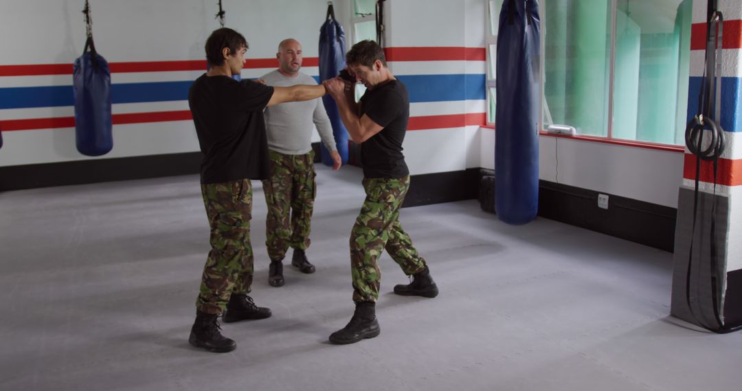 Self-Defense Class with Instructor Overseeing Martial Arts Practice - Free Images, Stock Photos and Pictures on Pikwizard.com