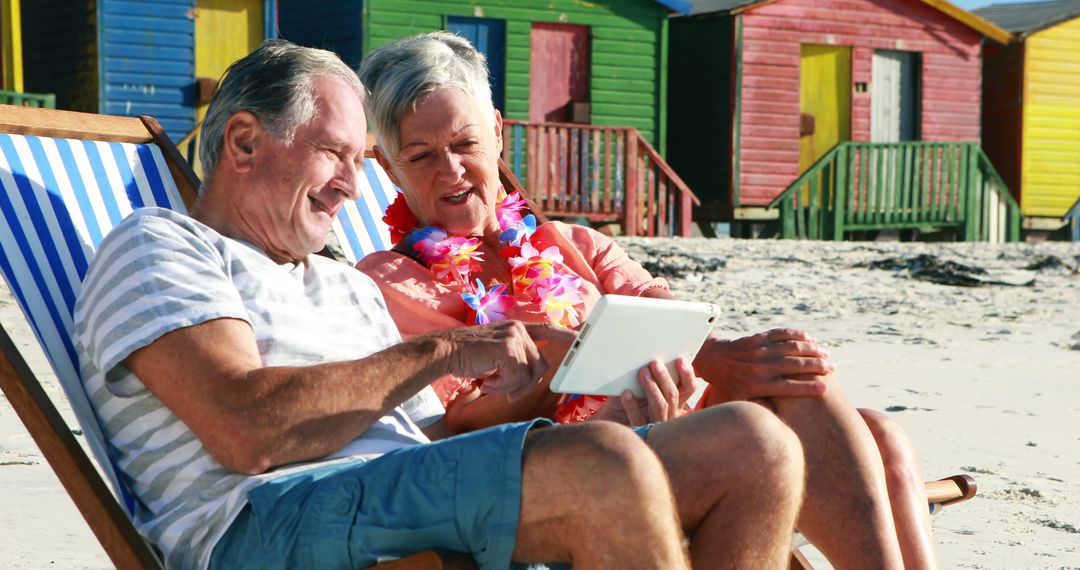 Senior Couple Relaxing on Beach with Tablet - Free Images, Stock Photos and Pictures on Pikwizard.com