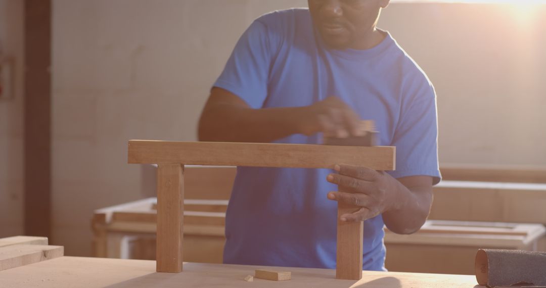 Skilled Craftsman Smoothing Wood in Workshop with Ambient Lighting