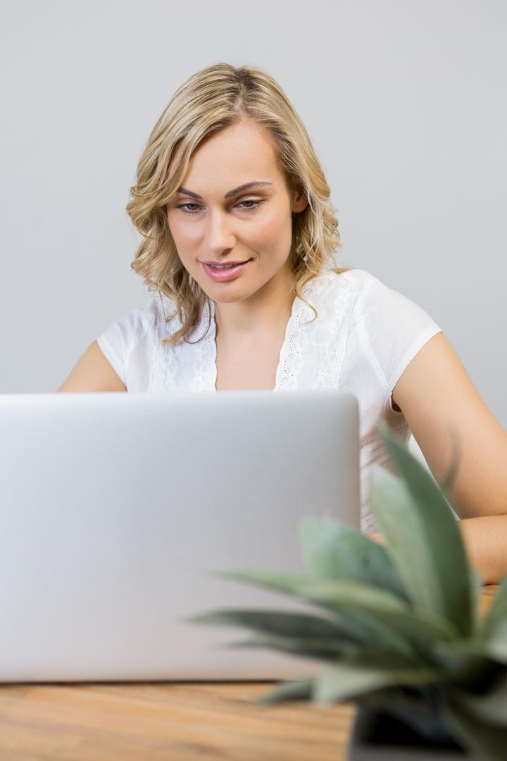 Smiling Woman Using Laptop at Home - Free Images, Stock Photos and Pictures on Pikwizard.com