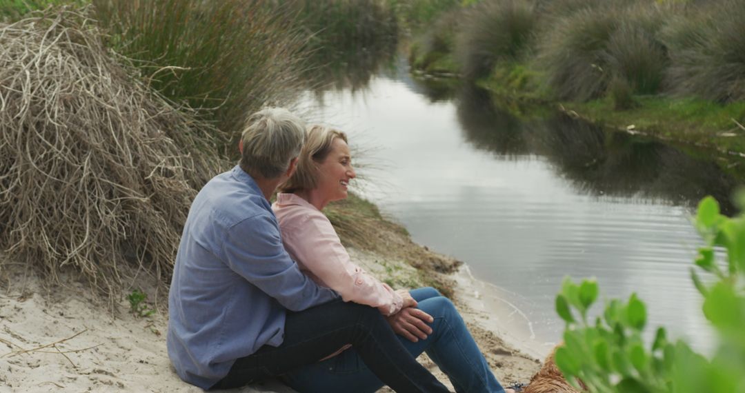 Senior Caucasian Couple Embracing by Riverside