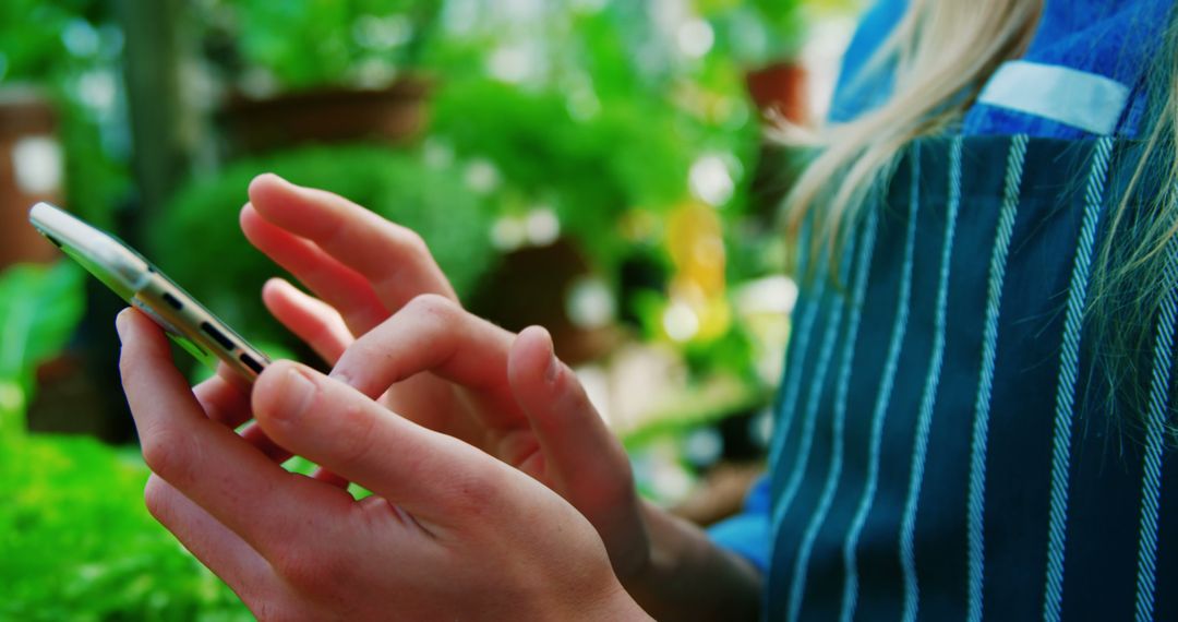 Female Gardener Using Smartphone in Greenhouse - Free Images, Stock Photos and Pictures on Pikwizard.com