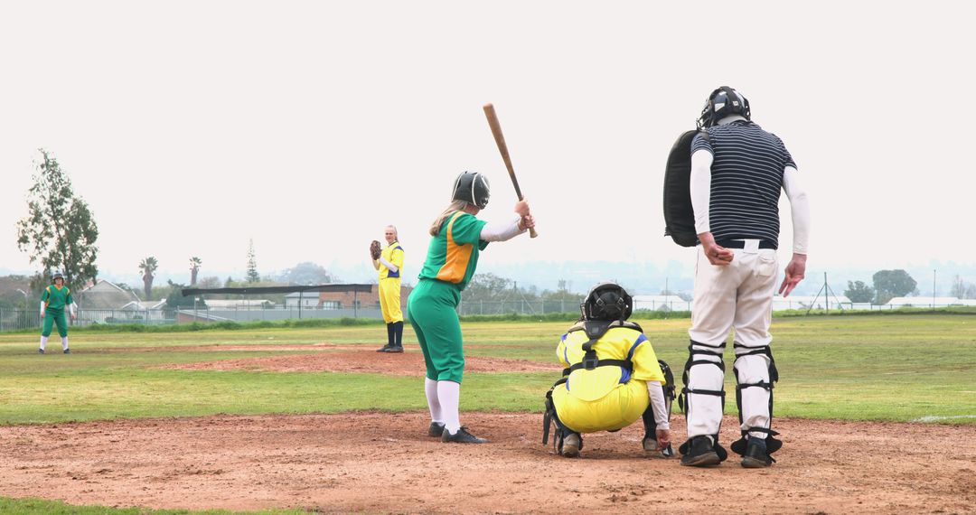 Softball Game Action on Community Field with Diverse Team