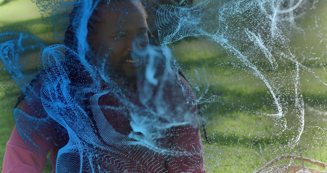 Smiling man with dreadlocks relaxing on park lawn with child and blue holographic overlay