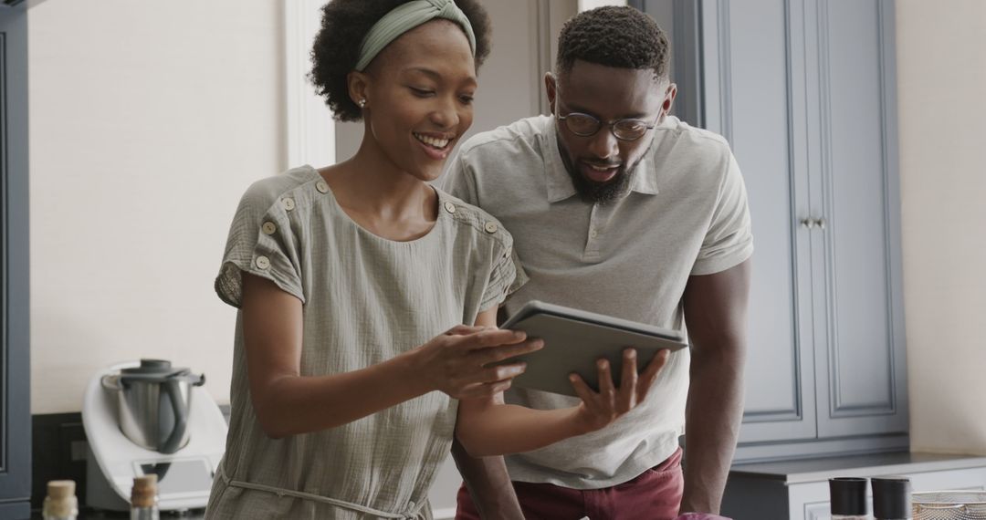Joyful African American Couple Cooking and Browsing Recipes