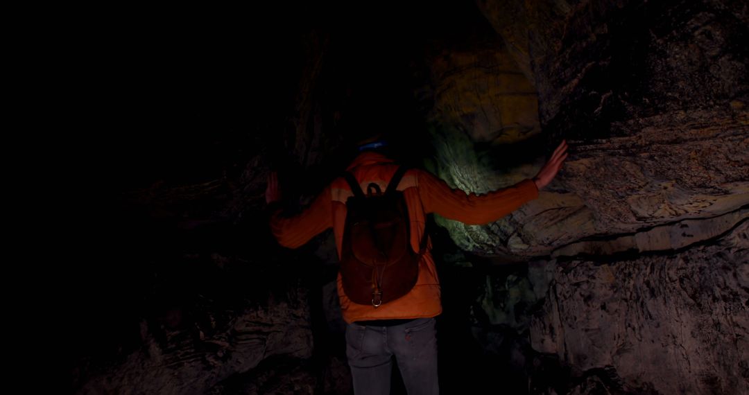 Man Exploring Mysterious Cave System in Darkness with Backpack