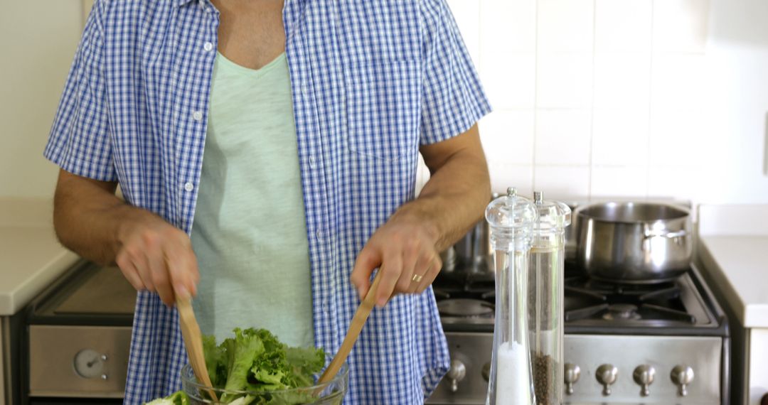 Young Man Preparing Fresh Salad in Modern Kitchen - Free Images, Stock Photos and Pictures on Pikwizard.com