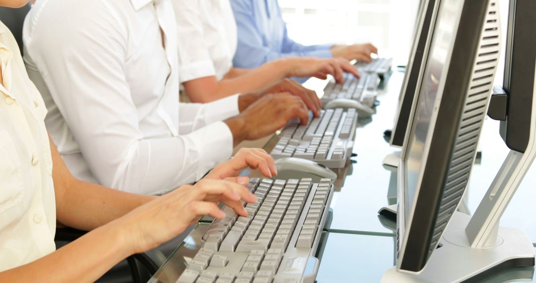 Office Workers Typing on Keyboards in Modern Workspace