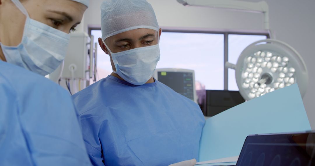 Surgeons Examining Patient Data in Operating Room - Free Images, Stock Photos and Pictures on Pikwizard.com