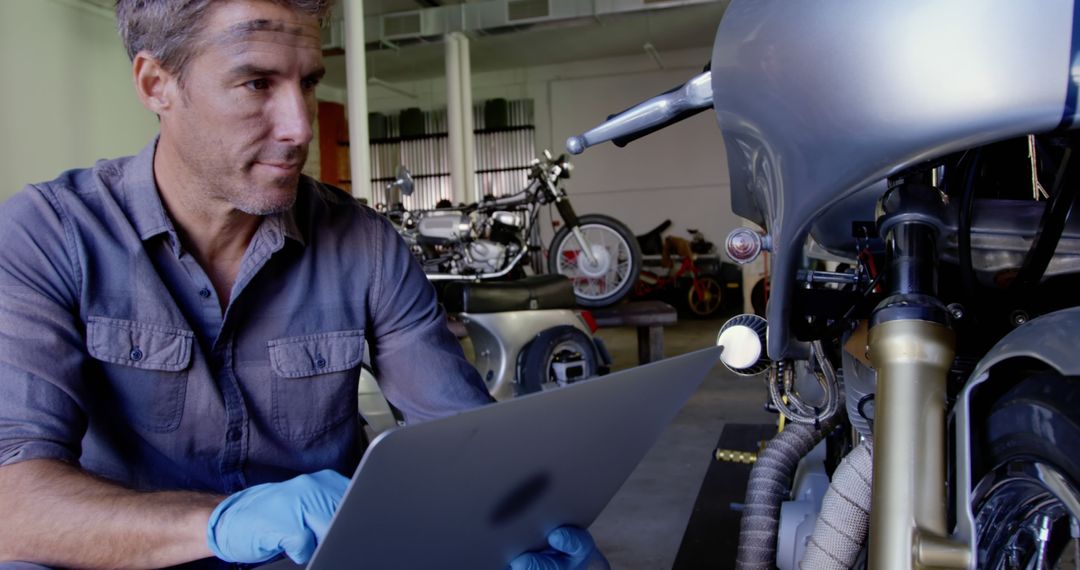 Mechanic Using Digital Tablet for Motorcycle Maintenance in Workshop - Free Images, Stock Photos and Pictures on Pikwizard.com