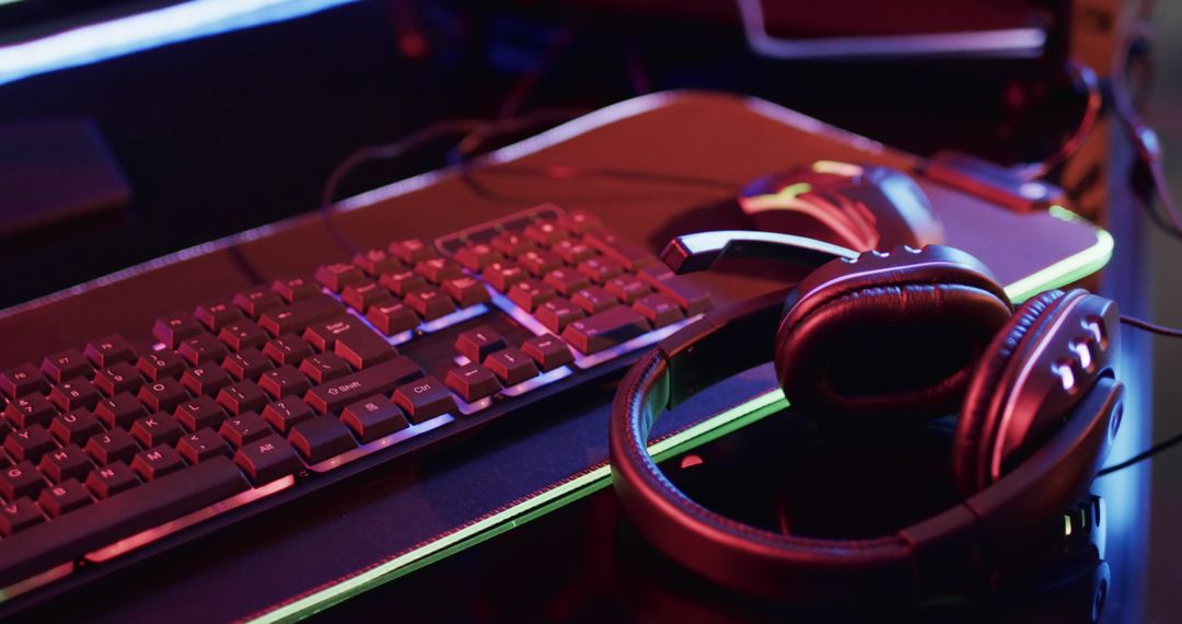 Gaming Setup Featuring RGB Keyboard and Headset in Neon Light