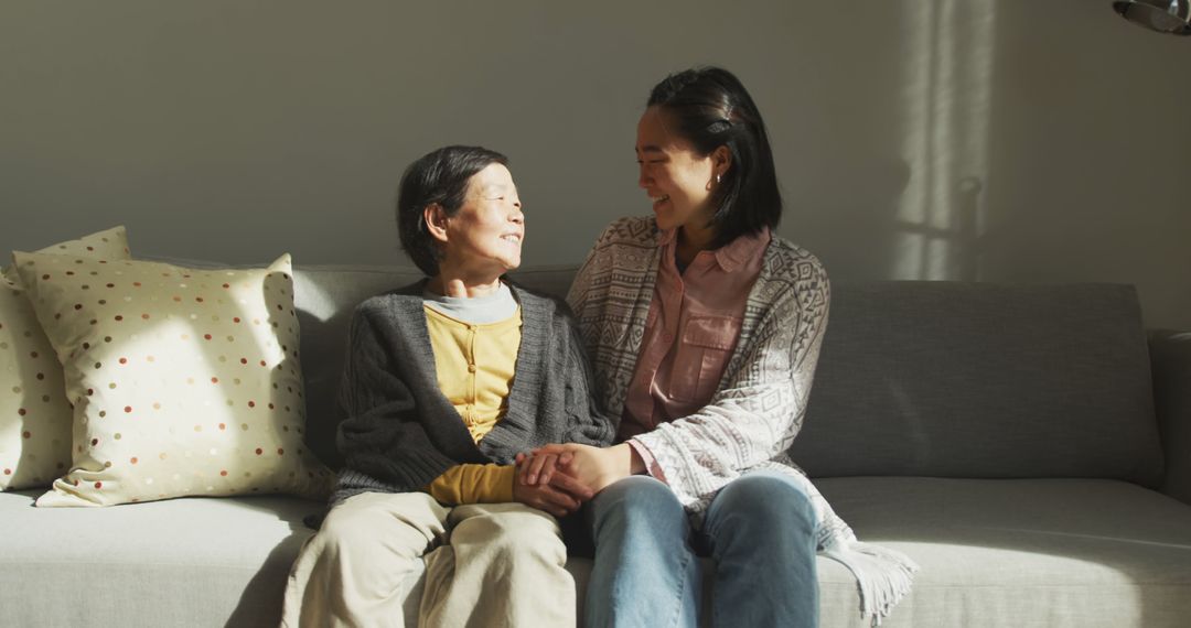 Elderly Woman and Young Woman Sharing a Candid Moment on Couch - Free Images, Stock Photos and Pictures on Pikwizard.com