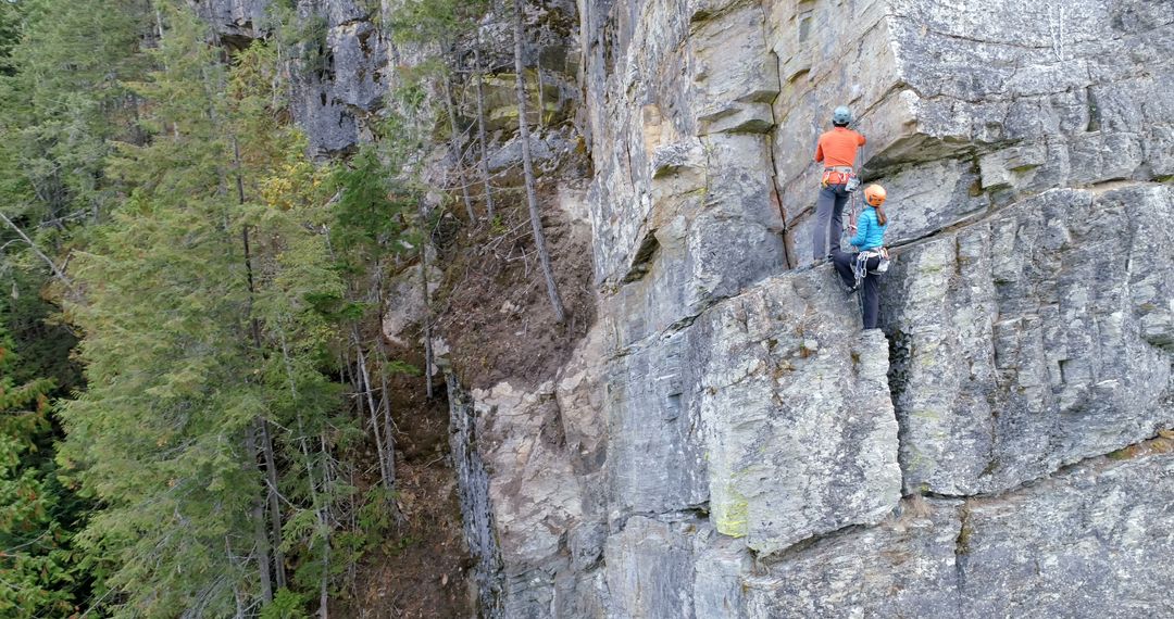 Couple Rock Climbing Together on Rugged Cliff Face