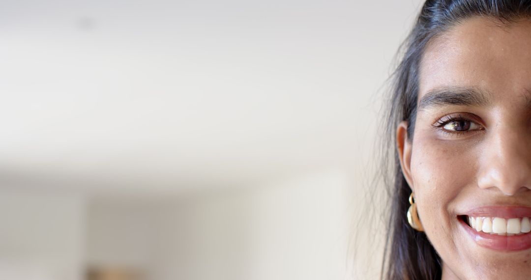 Smiling Woman Showing Hoop Earrings in Bright Space