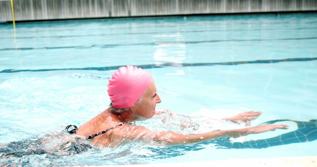 Older Woman Enjoying Swimming in Pool with Pink Swim Cap - Free Images, Stock Photos and Pictures on Pikwizard.com