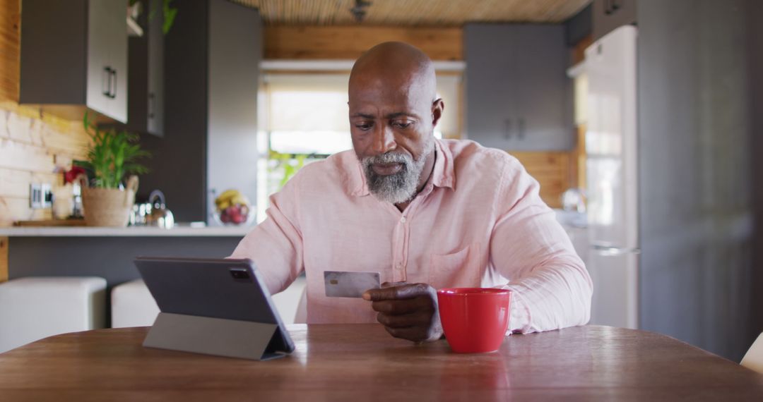 Senior African American Man Shopping Online with Tablet and Credit Card in Kitchen - Free Images, Stock Photos and Pictures on Pikwizard.com