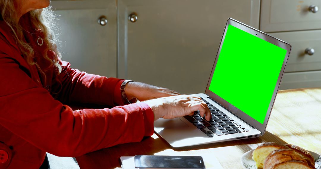 Senior Woman Using Laptop with Green Screen in Kitchen - Free Images, Stock Photos and Pictures on Pikwizard.com