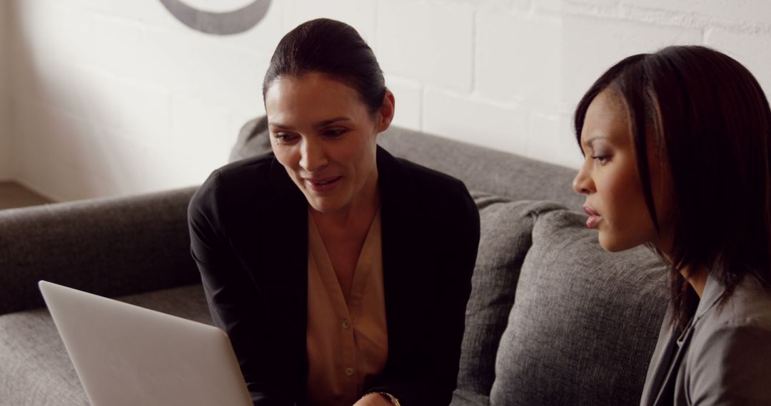 Diverse Business Professionals Collaborating on Laptop Project