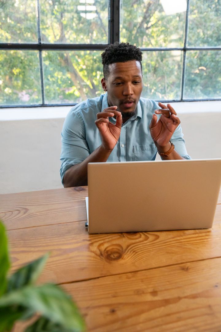 African American Man Gesturing While Video Conferencing in Modern Office