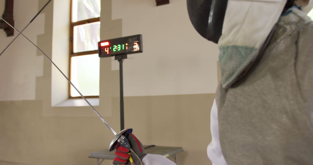 Fencing Athlete Competing During Match While Scoreboard Shows Scores - Free Images, Stock Photos and Pictures on Pikwizard.com