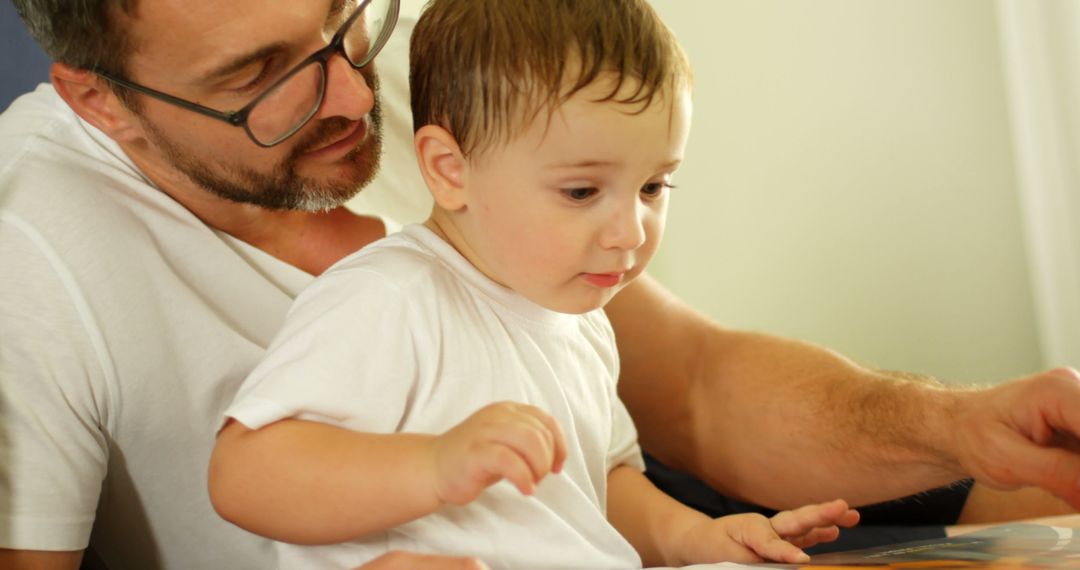 Father Reading a Book with Young Son at Home - Free Images, Stock Photos and Pictures on Pikwizard.com