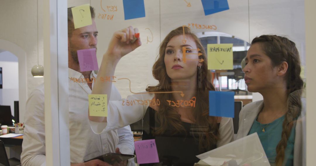 Diverse Team Brainstorming Using Sticky Notes in Modern Office