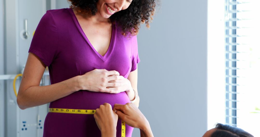 Pregnant Woman in Purple Dress Being Measured by Healthcare Professional - Free Images, Stock Photos and Pictures on Pikwizard.com