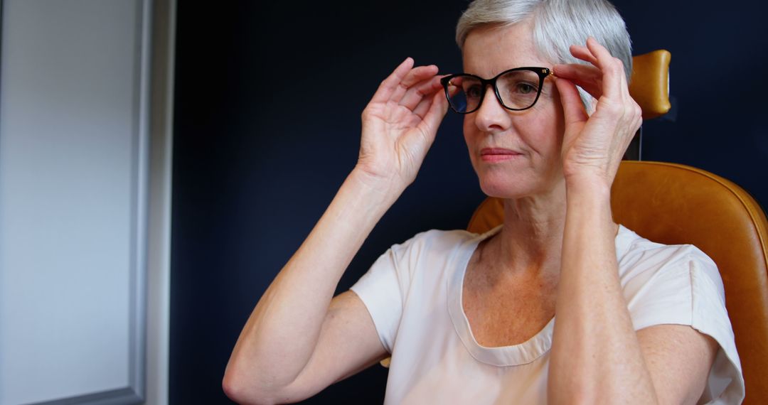 Senior Woman Adjusting Glasses in Modern Home Office - Free Images, Stock Photos and Pictures on Pikwizard.com