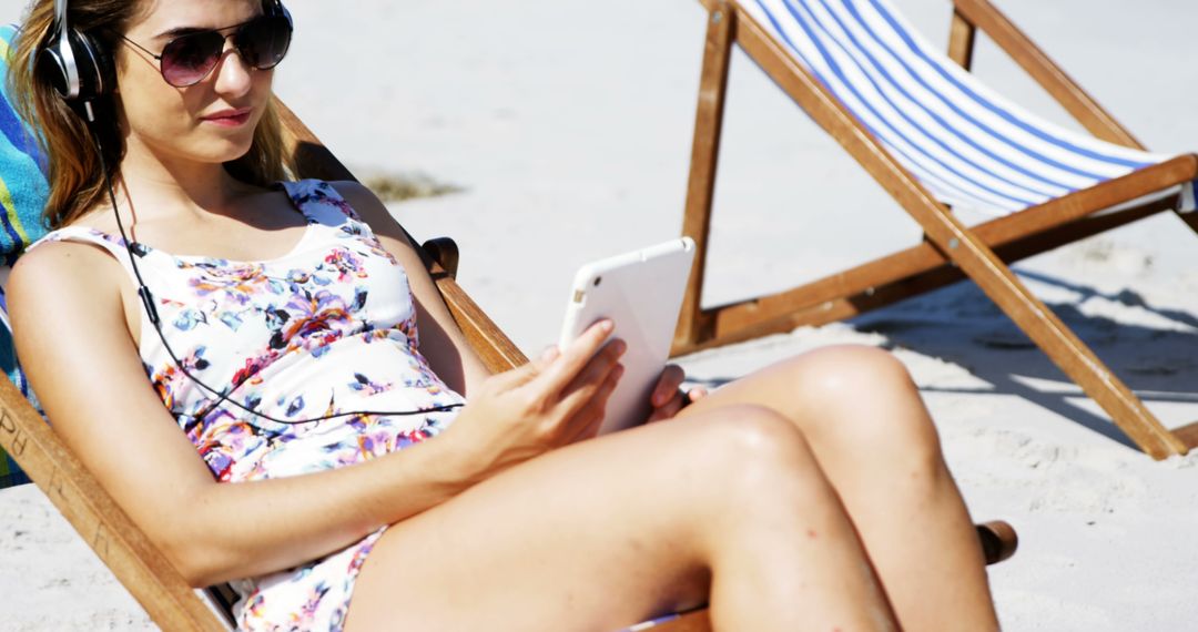A young Caucasian woman relaxes on a beach chair using her smartphone, with copy space - Free Images, Stock Photos and Pictures on Pikwizard.com