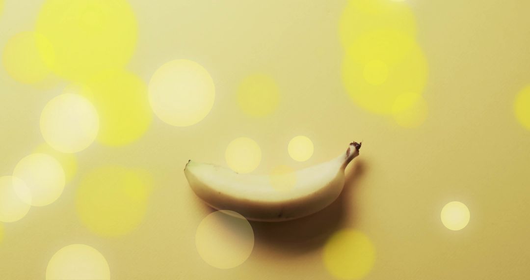 Single Banana on Luminous Yellow Background with Light Spots