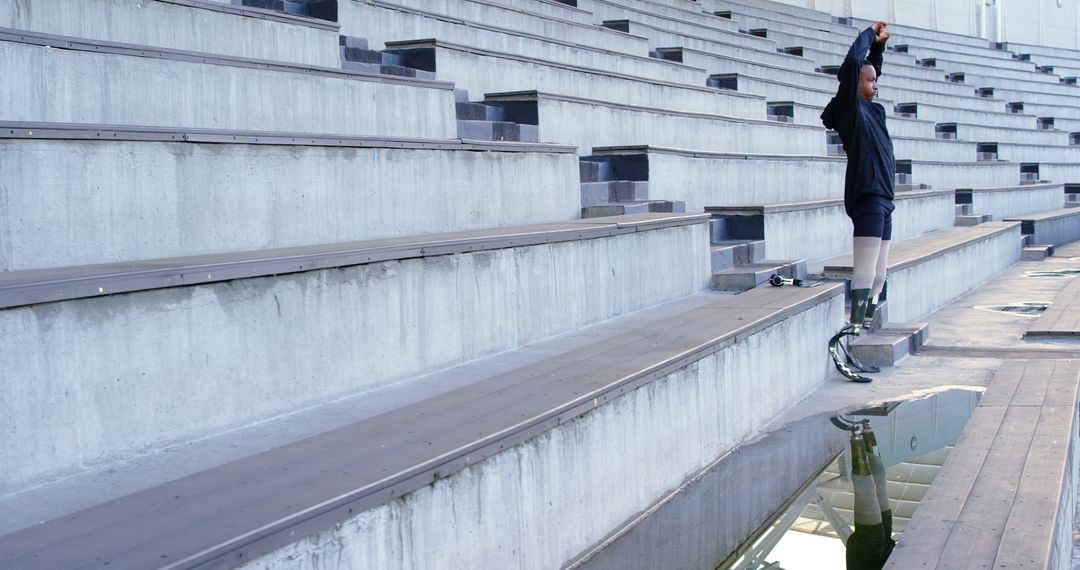 Athlete with Prosthetics Stretching in Empty Stadium - Free Images, Stock Photos and Pictures on Pikwizard.com