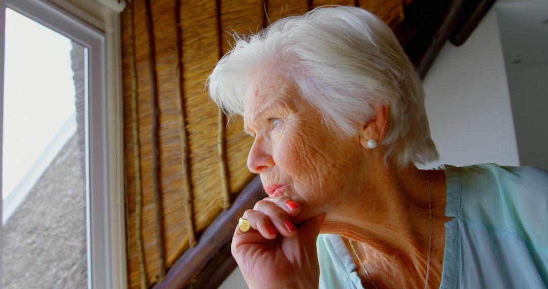 Thoughtful Elderly Woman Looking Out Window - Free Images, Stock Photos and Pictures on Pikwizard.com