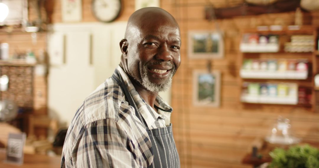 Smiling Mature Man in Plaid Shirt and Apron Standing in Cozy Workshop - Free Images, Stock Photos and Pictures on Pikwizard.com