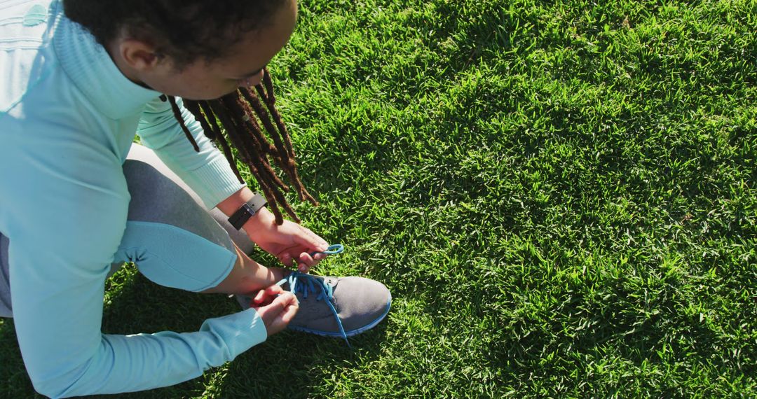 Woman Tying Running Shoes on Grass Field - Free Images, Stock Photos and Pictures on Pikwizard.com