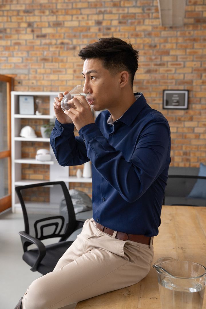 Professional Man Drinking Water in Modern Office Space