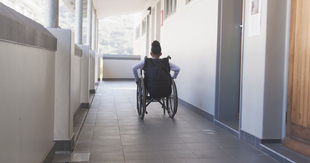 Student in Wheelchair Exploring School Hallway with Backpack