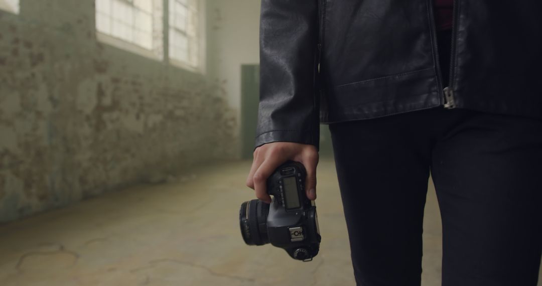 Photographer Holding Camera in Abandoned Industrial Building - Free Images, Stock Photos and Pictures on Pikwizard.com