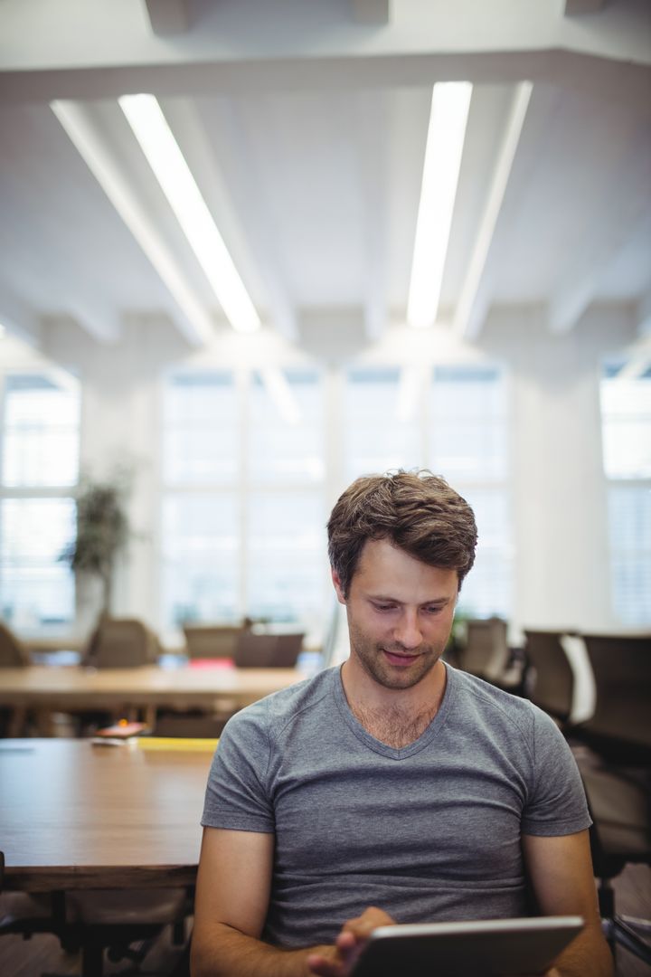 Young Professional Using Tablet in Modern Office Setting