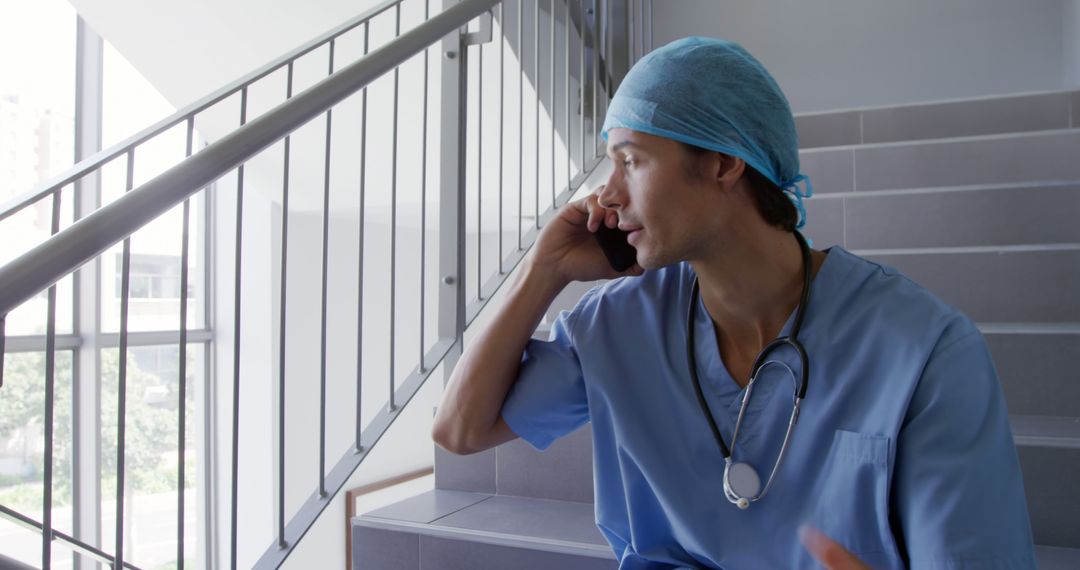 Young doctor wearing scrubs taking break while talking on phone - Free Images, Stock Photos and Pictures on Pikwizard.com