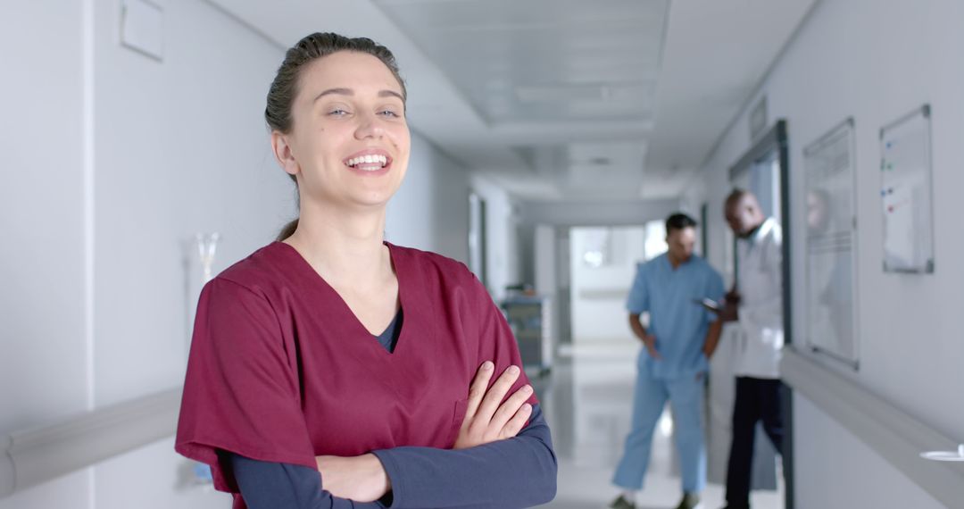 Confident Female Nurse in Hospital Corridor with Colleagues - Free Images, Stock Photos and Pictures on Pikwizard.com