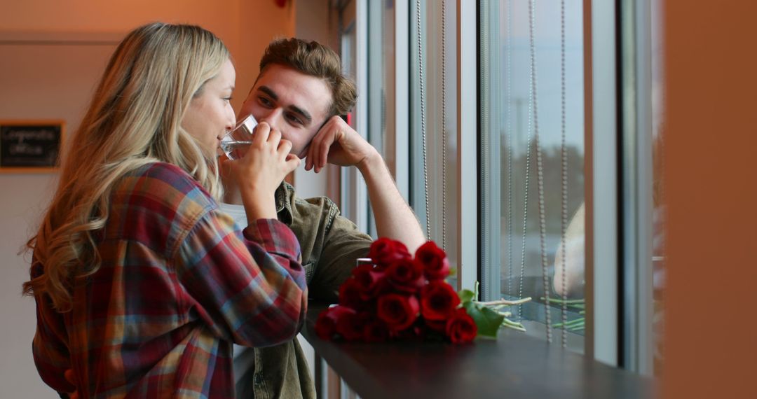 Romantic Couple Enjoying Coffee by the Window with Red Roses - Free Images, Stock Photos and Pictures on Pikwizard.com