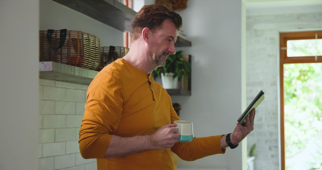 Middle-aged Man Using Tablet in Modern Kitchen