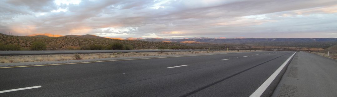 Scenic Highway Stretch with Distant Mountains at Sunset - Free Images, Stock Photos and Pictures on Pikwizard.com